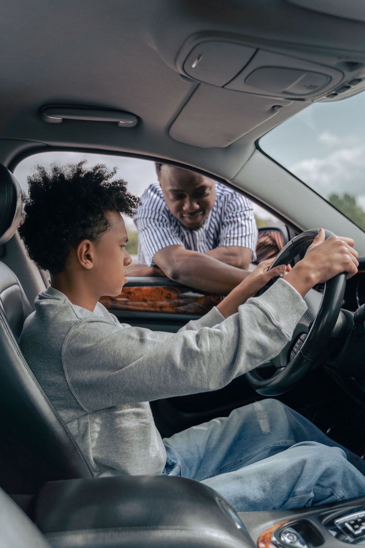 Driving instructor guiding a learner driver at the wheel